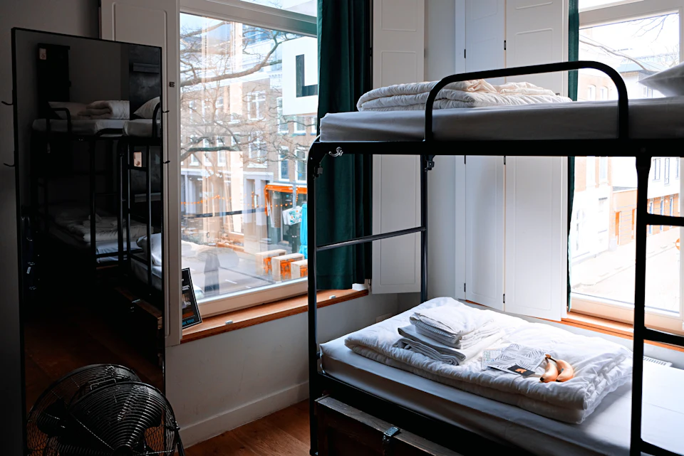 Bunk beds with folded towels in a bright hostel room
