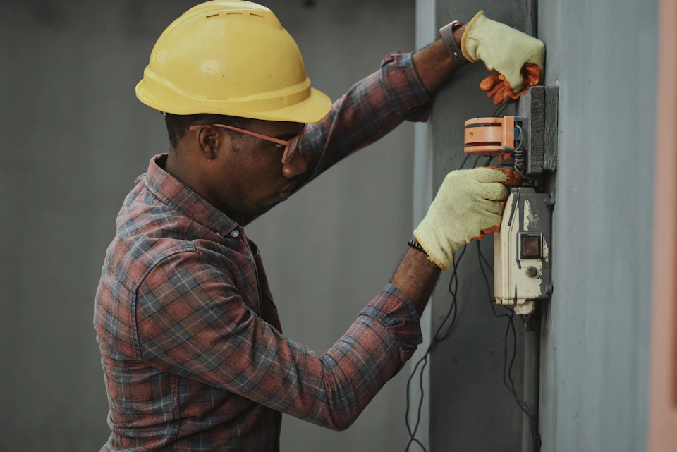 A maintenance technician working on an electrical panel