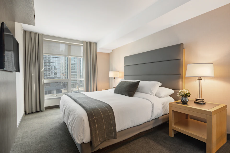 A clean, modern city hotel room with a large window